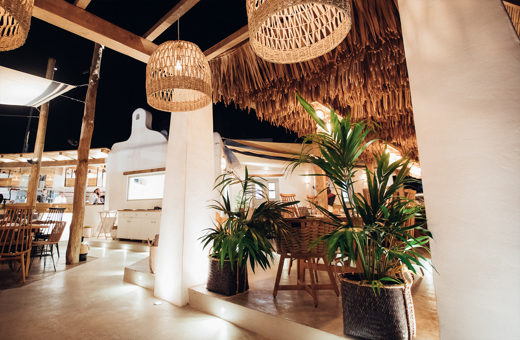 Timber restaurant pergola with woven pendant lights and integrated floor lighting