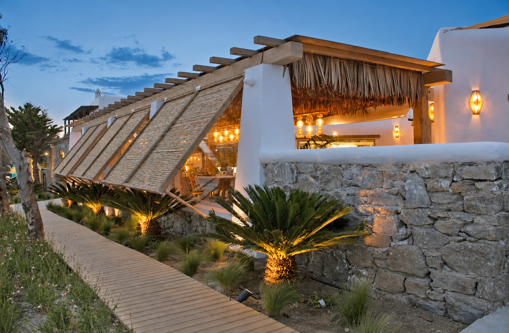 Mykonos restaurant dining area with warm lighting, timber furniture and natural textures
