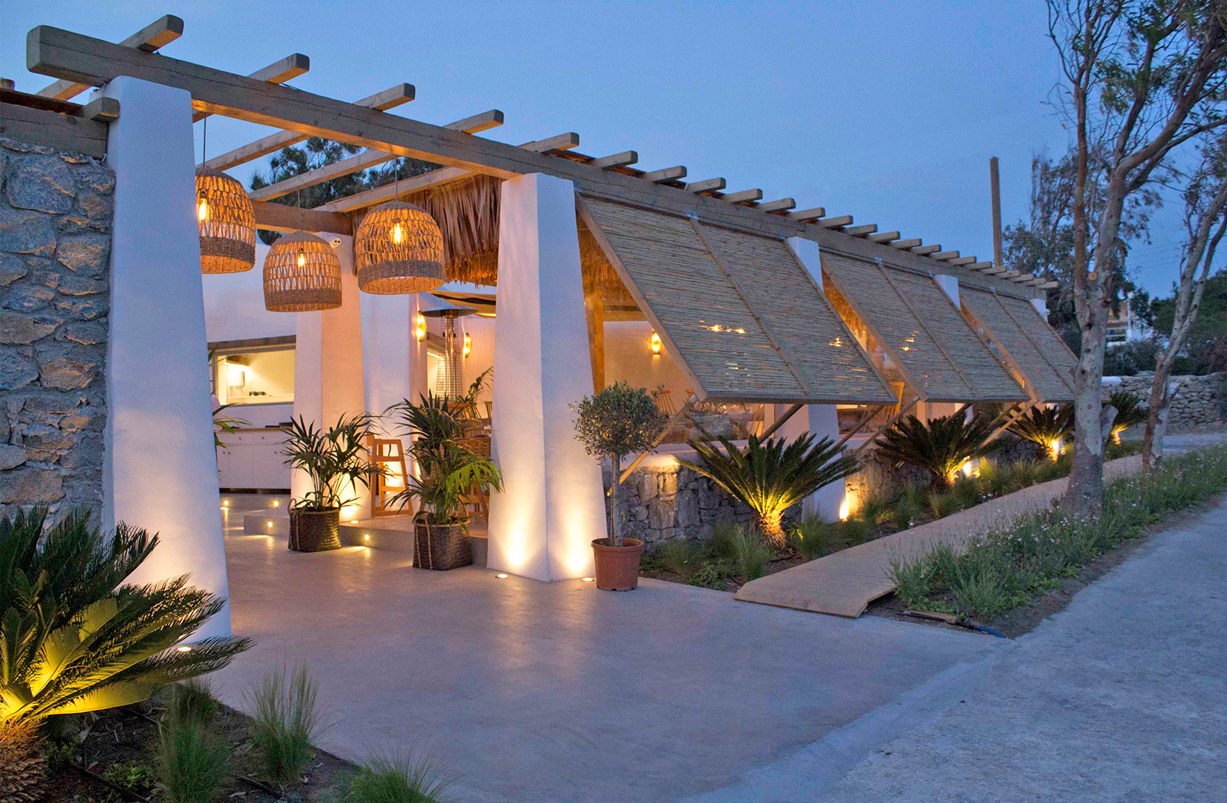 Mediterranean restaurant in Mykonos with natural wood, woven lighting and open-air dining