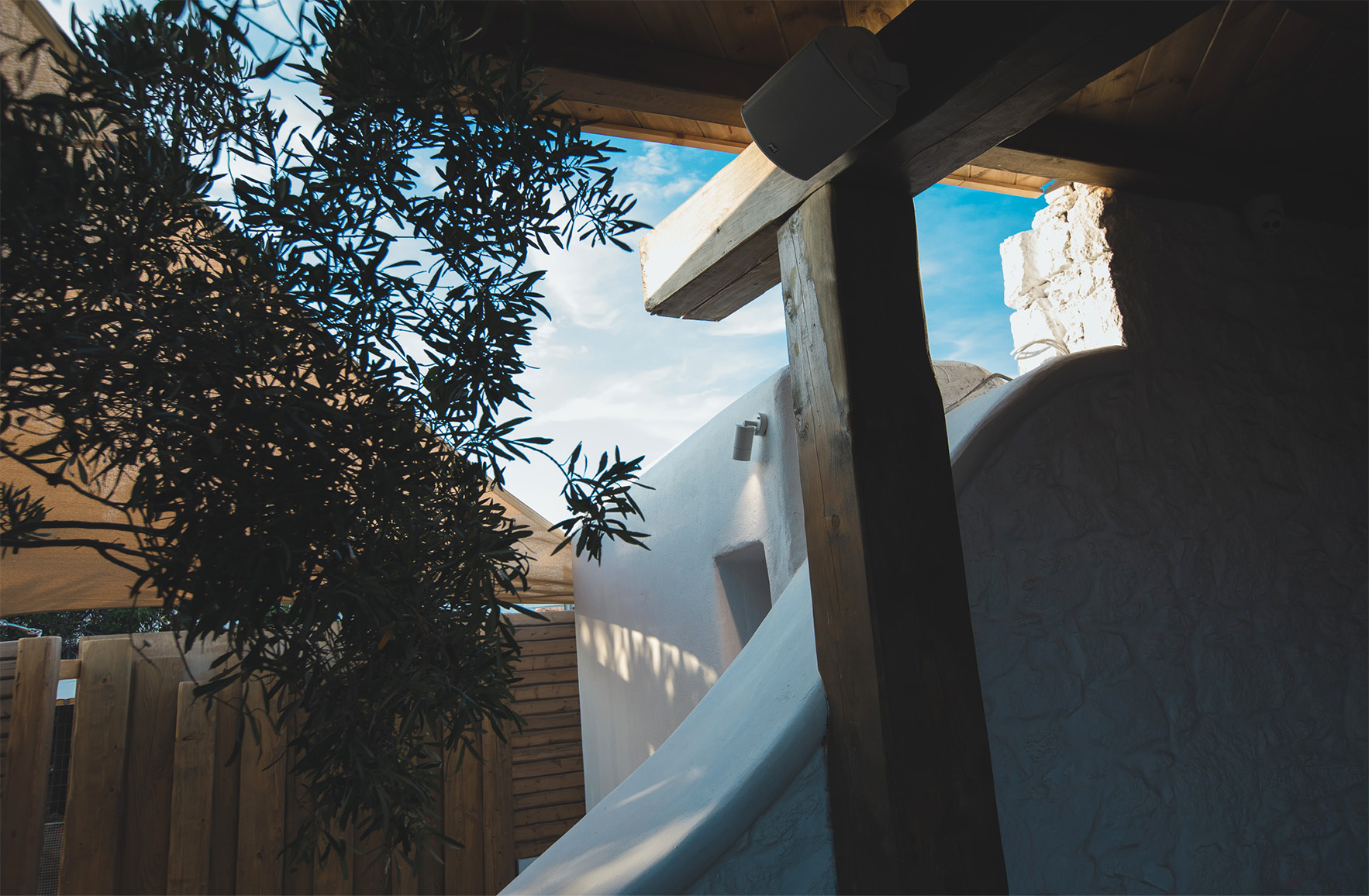 A timber pergola creates rhythm, shade and intimacy within the outdoor dining area.