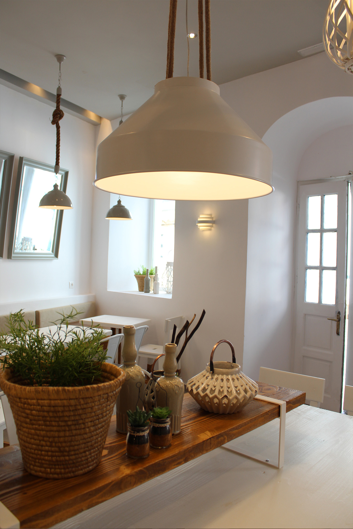 Large rope-suspended pendant light above the communal table inside Souvlaki Story restaurant in Mykonos.
