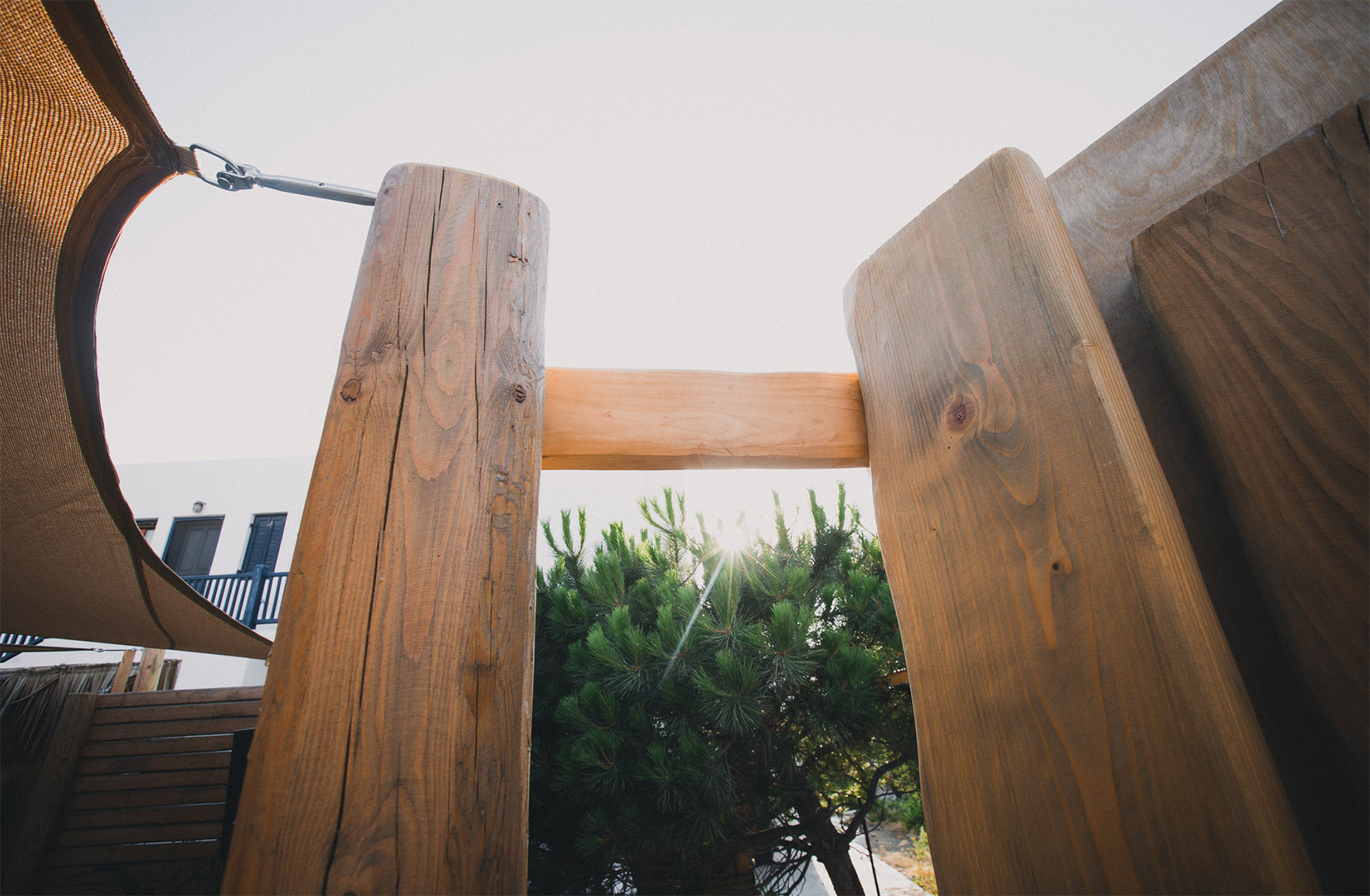 Natural timber fence detail with Mediterranean planting in a hospitality project in Mykonos